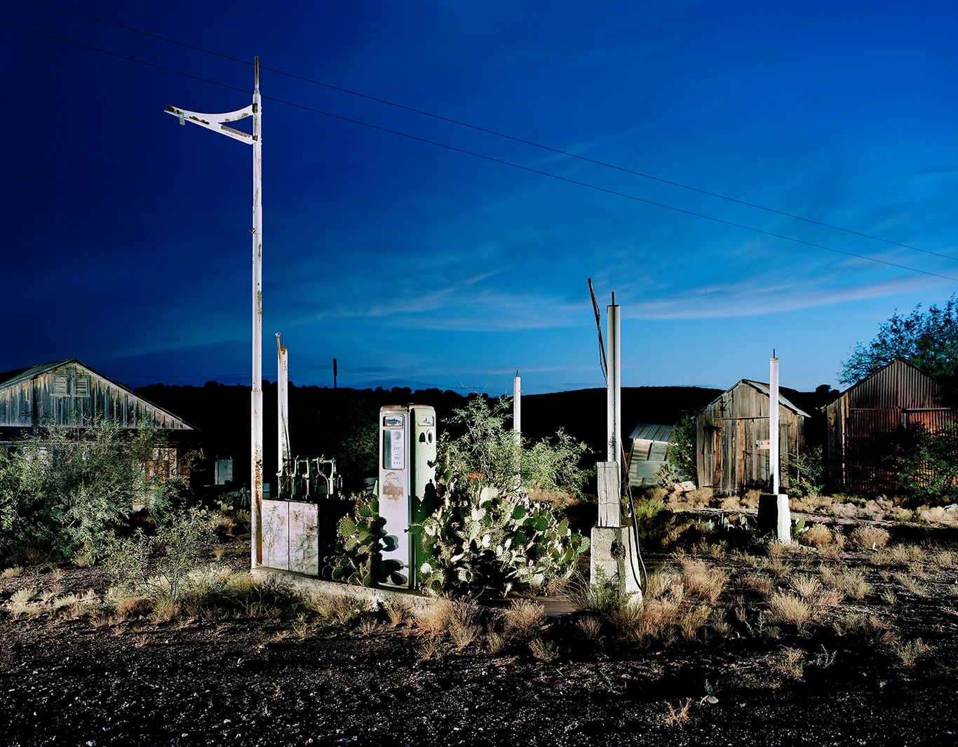 lit-up petrol station in the ghost town of Cordes, Arizona, at dusk