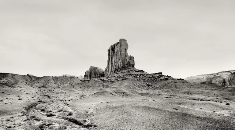 Schwarzweiß-Fotografie des Elephant Butte im Monument Valley, aufgenommen als hochaufragende Klippe, die an einen Schiffsbug erinnert
