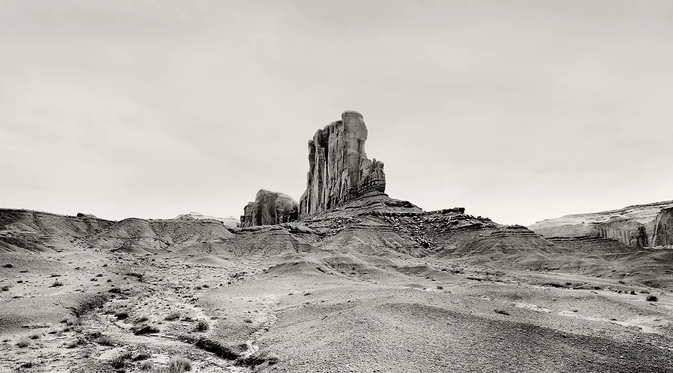 Schwarzweiß-Fotografie des Elephant Butte im Monument Valley, aufgenommen als hochaufragende Klippe, die an einen Schiffsbug erinnert