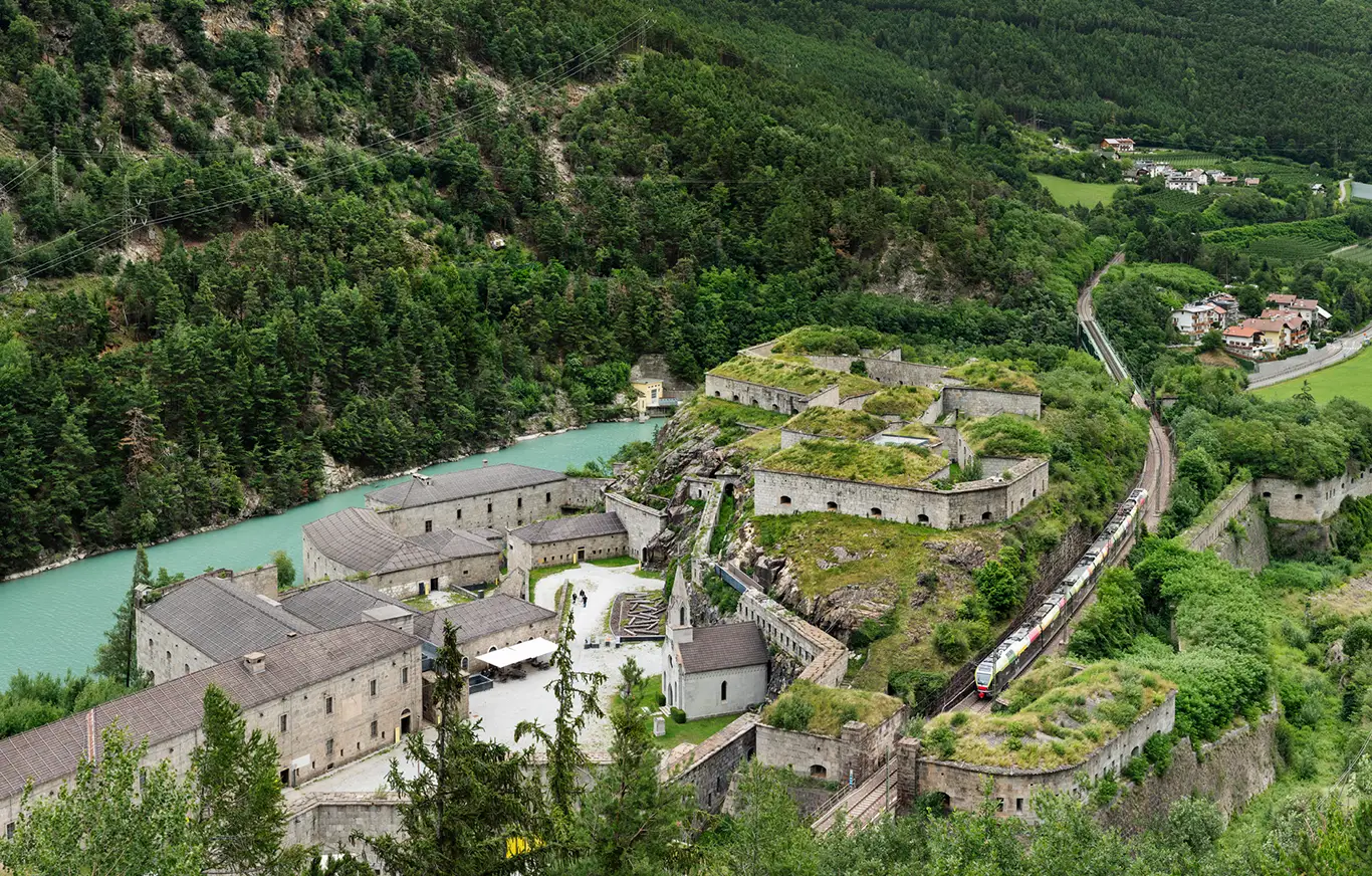 Zug der Pustertalbahn fährt durch die Festung Franzensfeste in Südtirol, Italien