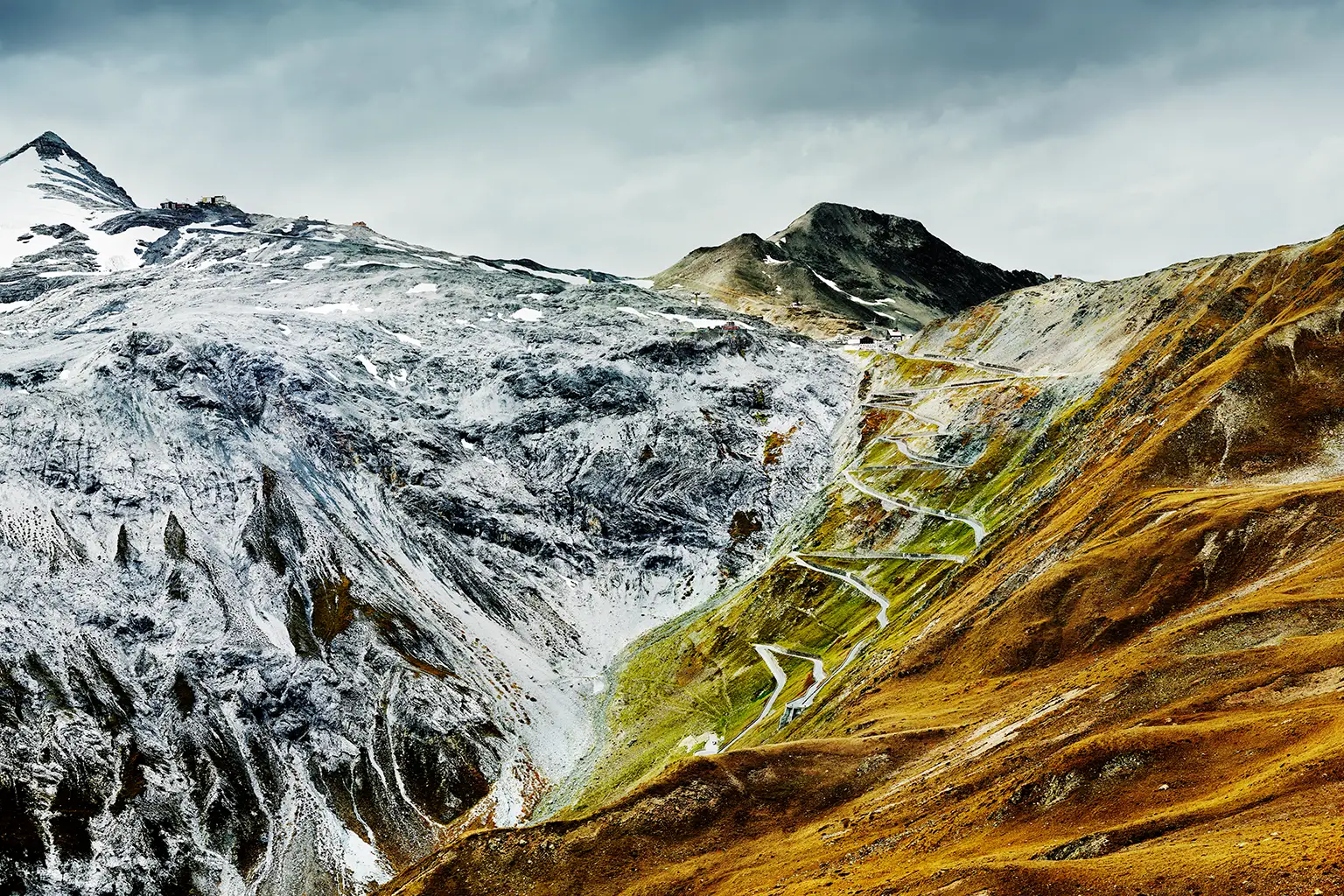 The eastern approach of the Stelvio Pass road, with its 48 hairpin bends, set against an autumnal high-mountain alpine landscape