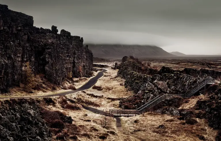 Weg zwischen dunklen Felsen auf der linken Seite in Thingvellir