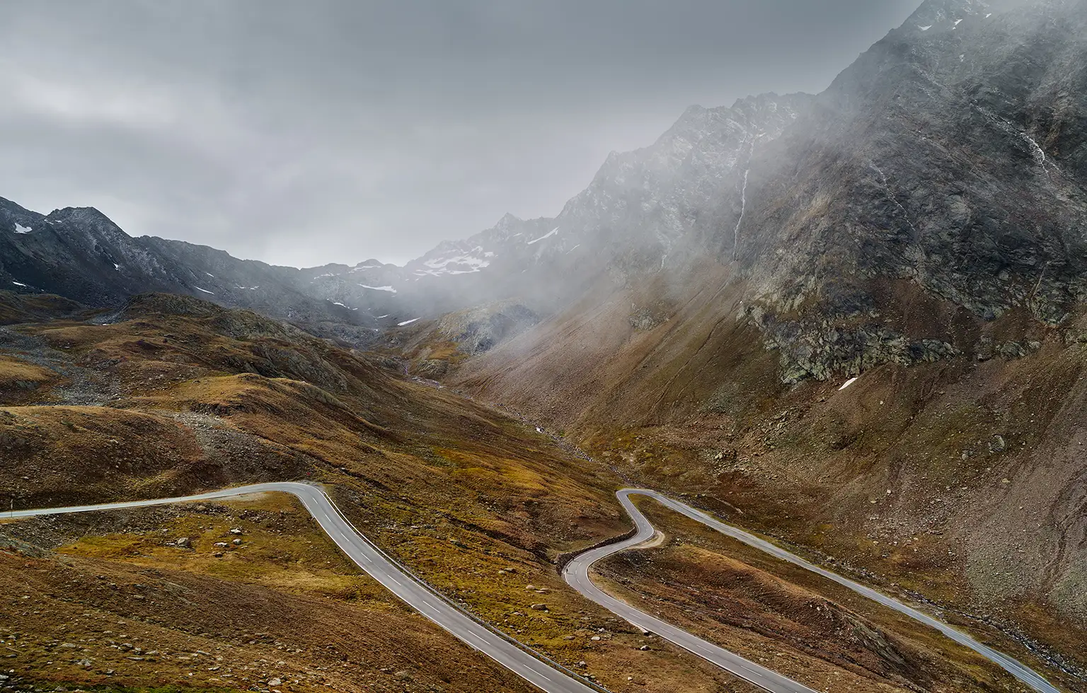 Nordwestrampe des Timmelsjoch (Passo del Rombo) kurz vor der Passhöhe im Timmelstal mit Serpentinen im alpinen Gelände zwischen Österreich und Italien, teilweise im Nebel.