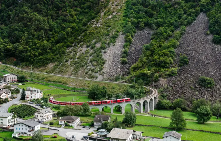 Ein Allegra-Triebwagen der Rhätischen Bahn auf dem Kreisviadukt von Brusio, dem Wahrzeichen der Berninabahn: neun Bögen, eine vollständige 360-Grad-Schleife, mit der die Strecke auf engstem Raum Höhe gewinnt