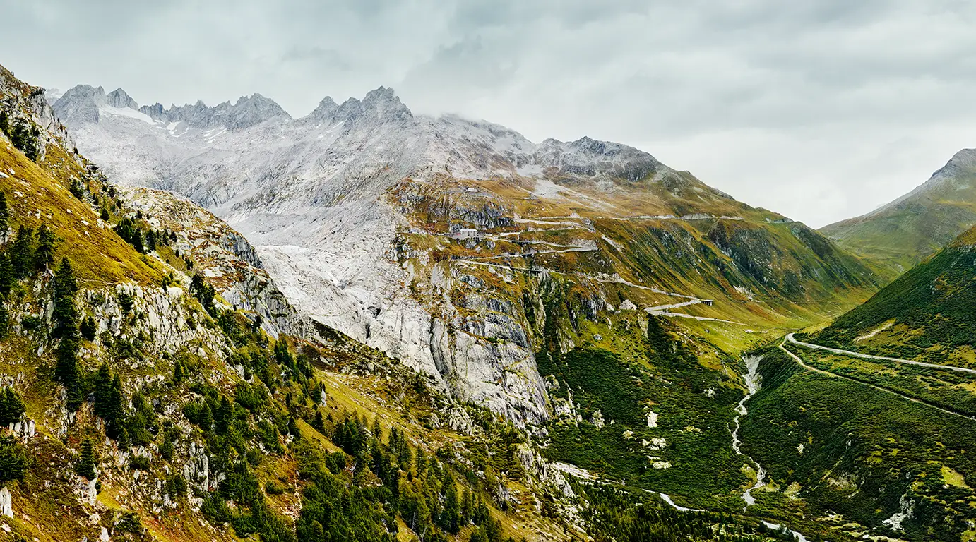 Berglandschaft auf der Westseite des Furkapass in herbstlicher Färbung an einem bedeckten Tag