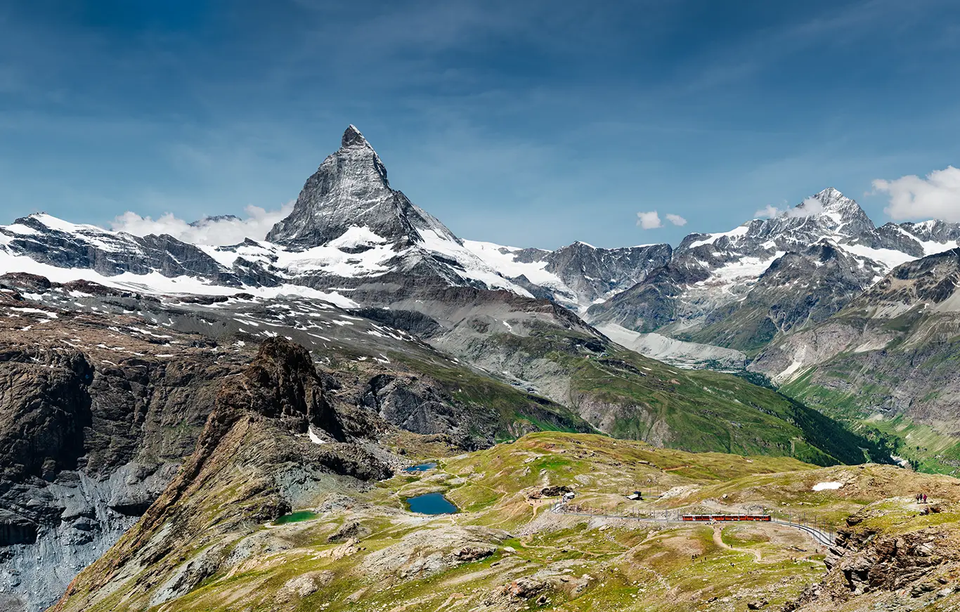 Zug der Bahnstrecke der Gornergratbahn zwischen Rotenboden und Gornergrat und Blick zum Matterhorn und hinunter zum Riffelsee