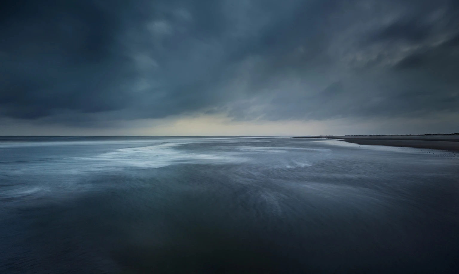 blaues Meer, dunkle Wolken, Ansicht der Nordsee am Nordstrand von Norderney
