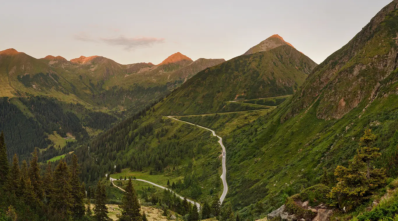 Straße durch die grüne Landschaft der Nordrampe am Sölkpass in den Niedern Tauern in der Steiermark
